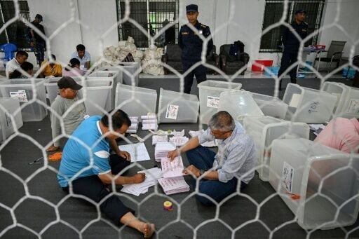 Electoral officials sort ballots at a counting centre in Damak, Jhapa district