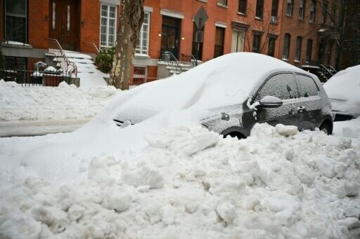A car in Brooklyn, New York is plowed in with snow a day after a winter storm swept across the nation