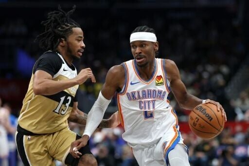 Shai Gilgeous-Alexander dribbles past Sharife Cooper on his way to 40 points in Oklahoma City's stormy win over Washington