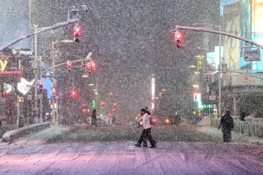 People walk across Times Square during the snowstorm