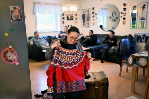 Dorthe Olsen holds up traditional clothing at her home in Sarfannguit