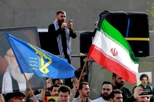 People wave flags of Iran and of its IRGC during a demonstration in Baghdad