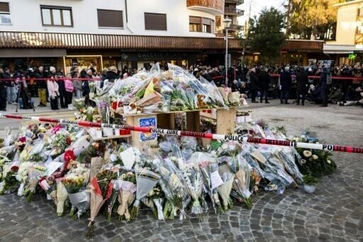 Flowers and candles in tribute to the victims are displayed at a makeshift memorial