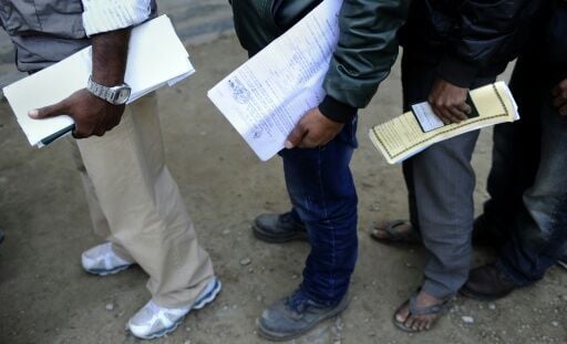 Nepali migrant workers queue to get permits to allow them to work abroad