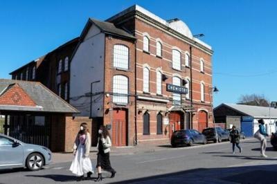 Pedestrians wearing face masks walk past Club Chemistry, a nightclub linked to an unprecedented deadly outbreak of meningitis in Canterbury, southeast England