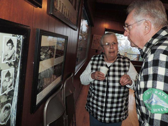 charlotte jones and  bill pattison look over photos that are part of the museum within Crag Rats hut.jpg