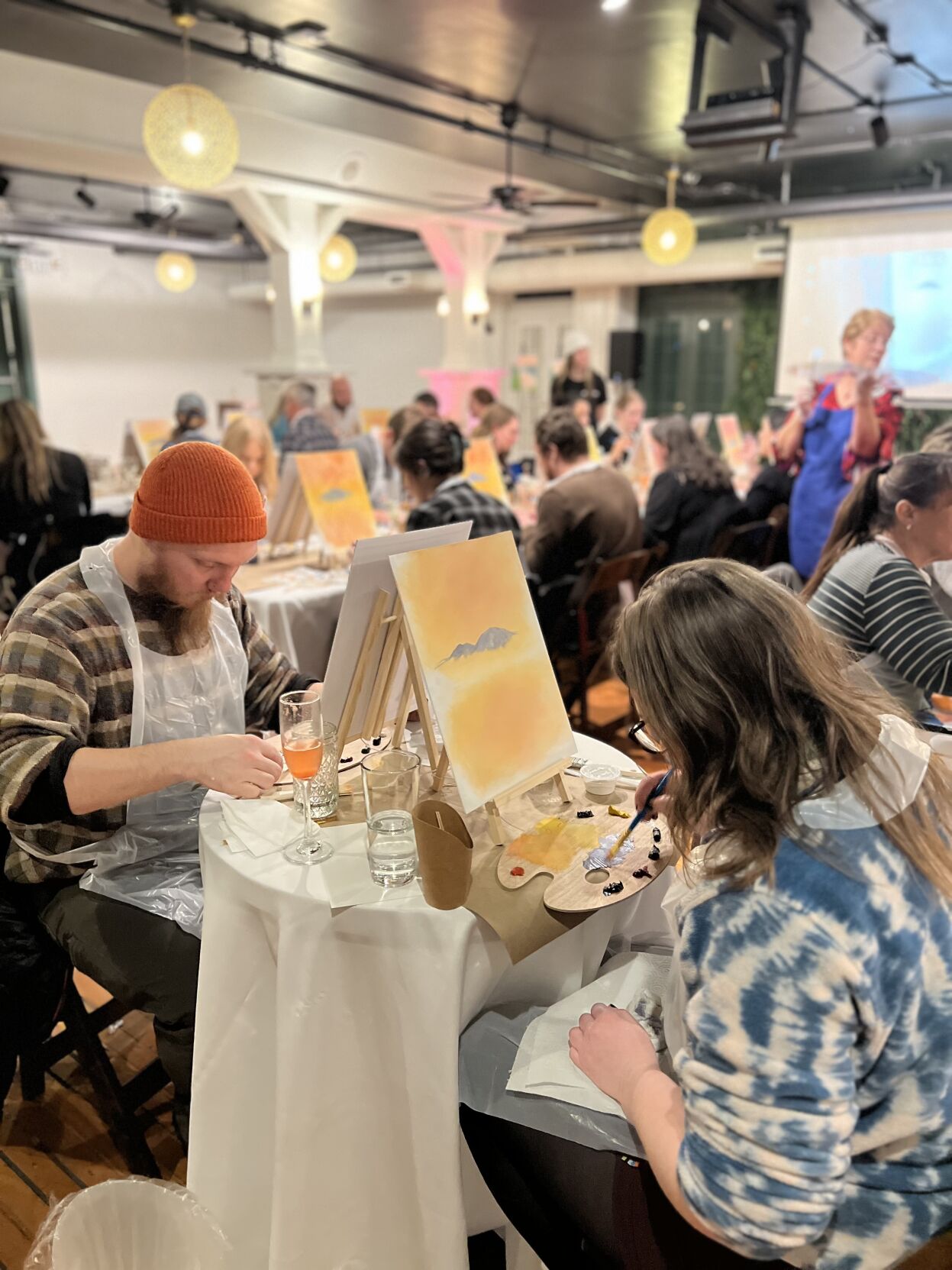 Artists enjoy their cocktails while using oil paints to create a sunset scene in the Gorge, taught by artist Vicki Brown. Photo courtesy of Rachel Rand.