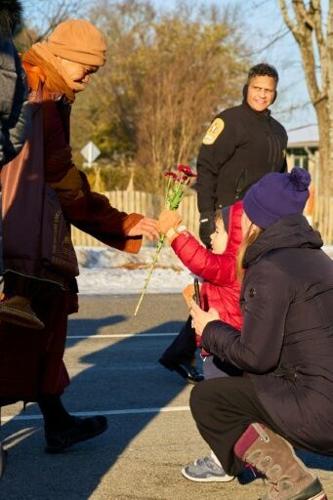 Bhikkhu Pannakara (L), leading Buddhist monks in a "Walk for Peace," receives a flower from a child as they walk in Richmond, Virginia