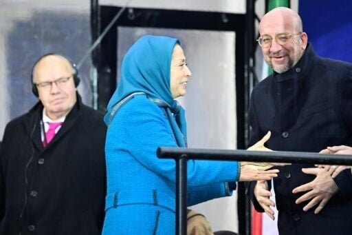 At the demonstration by the MEK, the group's leader Maryam Rajavi (C) welcomed former European Council chief Charles Michel (R) and former German economy minister Peter Altmaier on stage