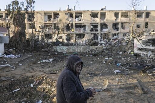 A man drinks a coffee as he looks at the houses destroyed in an Iranian missile strike in Dimona on March 22, 2026
