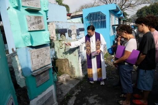 Roman Catholic priest Father Flavie Villanueva blesses the tomb of Edward Sentorias who died during former Philippine president Rodrigo Duterte's war on drugs, at a cemetery in Manila on February 16, 2026