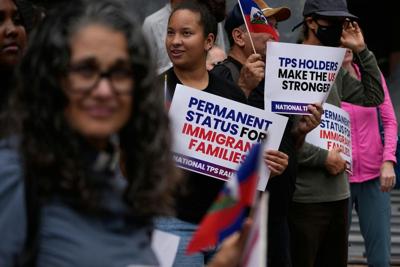 People hold Haitian flags and signs during a July 2026 rally in San Diego in support of immigrants living in the U.S. with Temporary Protected Status.