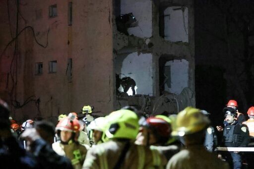 First responders inspect the site of an Iranian missile strike in Arad, Israel