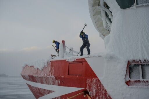 Crew members of the Sarfaq Ittuk ferry de-ice the bow with sledgehammers