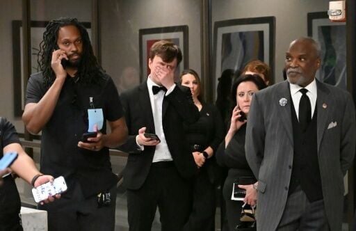 Attendees check their phones in the lobby of the Washington Hilton after shots were heard