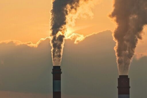 Smoke rises from chimneys at a power plant during sunset in Taicang, in eastern China's Jiangsu province