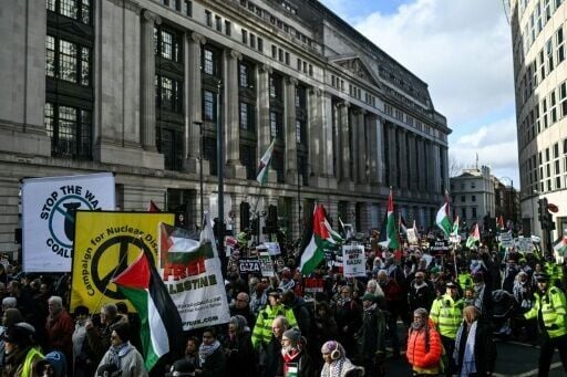 Protesters hold placards and wave Palestinian flags during a march organised by the Palestine Solidarity Campaign in central London on January 31, 2026.