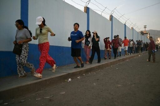 People run to cast their votes at a school polling station in Pamplona Alta, in the San Juan de Miraflores district on the outskirts of Lima