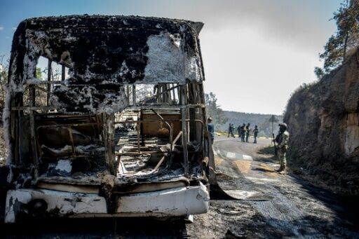 Members of the Mexican National Guard and Army inspected vehicles set on fire in Michoacan state after the killing of the drug kingpin