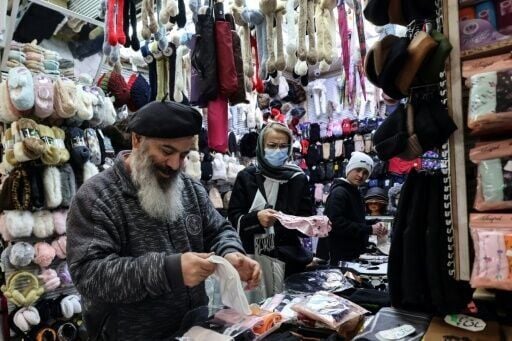 A shopkeeper tidies his stall in Tajrish Bazaar in the Iranian capital. Some traders have protested the rising price of imports as the rial falls against the dollar