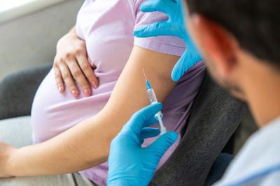 A pregnant woman awaits a vaccination