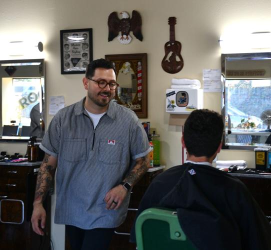 Owner Miguel “Mikey” Rocha cuts a clients hair.