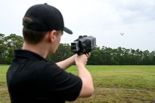 A DroneShield team member is holding a DroneGun Mk4 pointed at a drone during a visit to DroneShield in Sydney on February 9, 2026