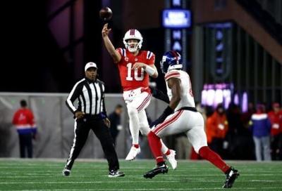 New England quarterback Drake Maye makes a pass under pressure in the Patriots' defeat of the New York Giants
