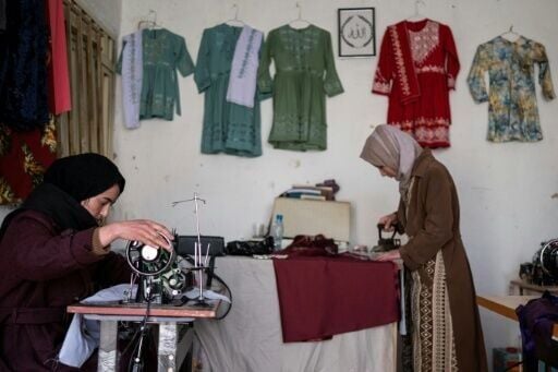Afghan Rahima Alavi (L), who runs an embroidery boutique in Bamiyan, feels proud she can support her family