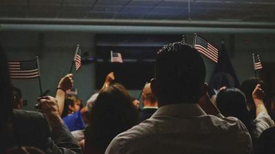People Waving American Flags Indoors