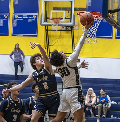 Talon Britt (30) scores a basket with contact against Canby.