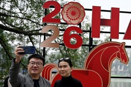 A couple takes a selfie next to a New Year's banner in Hanoi
