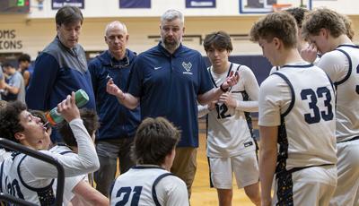 Coach Dirks talk with his team during a timeout against Canby earlier this year.