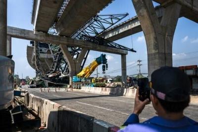 A highway construction crane collapsed near Bangkok on Thursday, killing two people, with Thailand's transport minister saying the firm involved was the same one whose machine fell at a China-backed rail project the day before, when 32 died