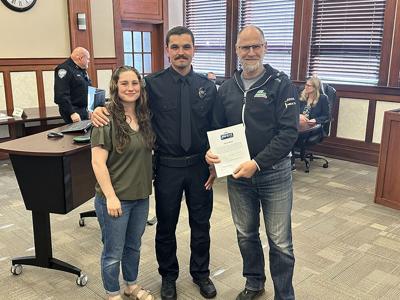 Mayor Paul Blackburn (right) smiles with Officer Wells (middle)