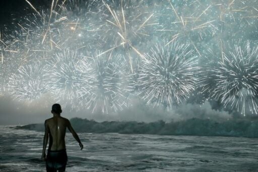 A man celebrates as he watches the traditional New Year's fireworks from the water at Copacabana Beach in Rio de Janeiro, Brazil, on January 1, 2026