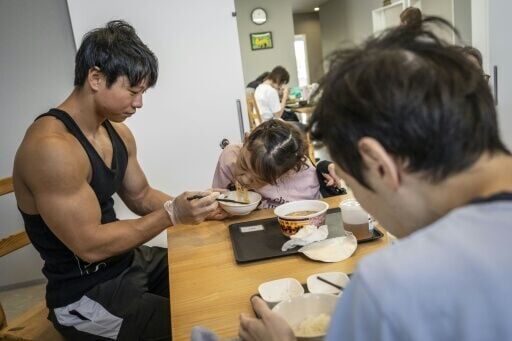Bodybuilder Takuya Usui (L) says he was lured into the care industry by a job that would put his muscles to good use