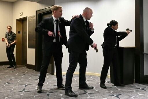 US security agents draw their guns after shots were heard during the White House Correspondents' Association dinner at the Washington Hilton