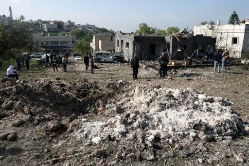 People gather at the site of a rocket strike in Zarzir, northern Israel