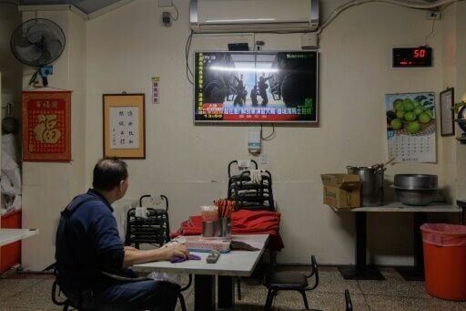 A man in Taiwan watches TV news coverage of the Chinese People's Liberation Army military drills this week, which Taipei called 'highly provocative'