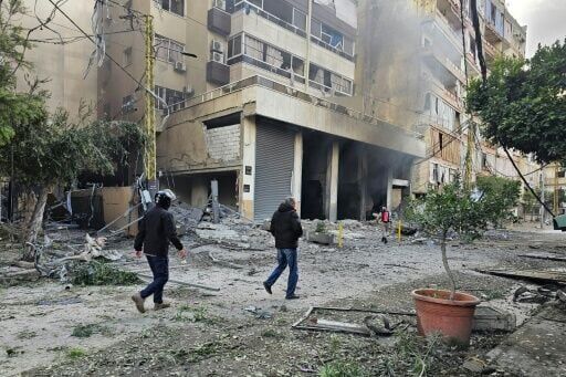 Firefighters inspect the site of an overnight Israeli airstrike on the Haret Hreik neighbourhood in Beirut's southern suburbs