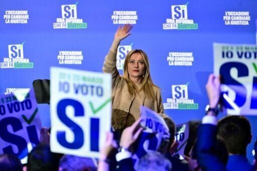 Italy's Prime Minister Giorgia Meloni waves to supporters at the end of a campaign meeting