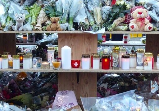 A continuous stream of well-wishers have left flowers and candles near Le Constellation