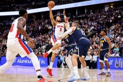 Detroit's Cade Cunningham drives against Denver's Jonas Valanciunas in the Pistons' road win