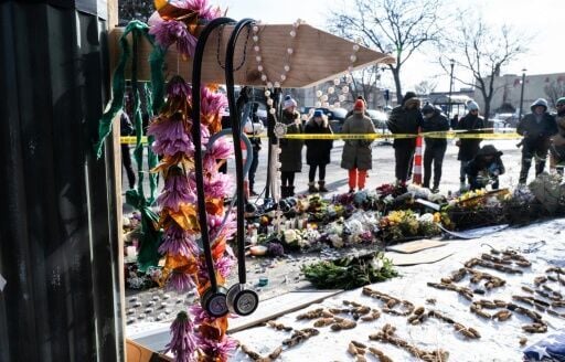 A stethoscope hangs on a cross as people gather at a makeshift memorial in the area where Alex Pretti was shot dead by federal immigration agents in Minneapolis, Minnesota, on January 26, 2026