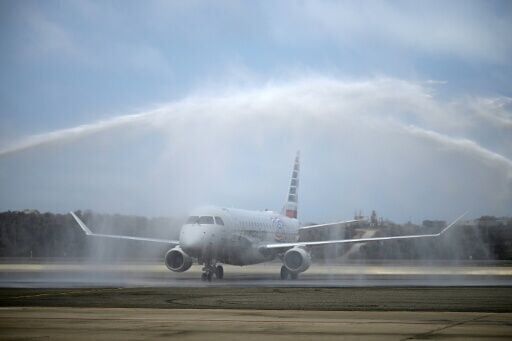 An American Eagle aircraft receives celebratory sprays of water after landing in Venezuela as the first direct flight from the United States in years