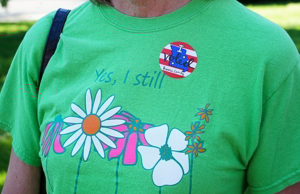 After voting, Chris Walker puts an I voted' sticker on her T-shirt