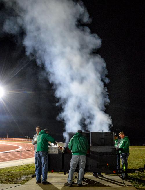 A group of volunteer parents grill hamburgers
