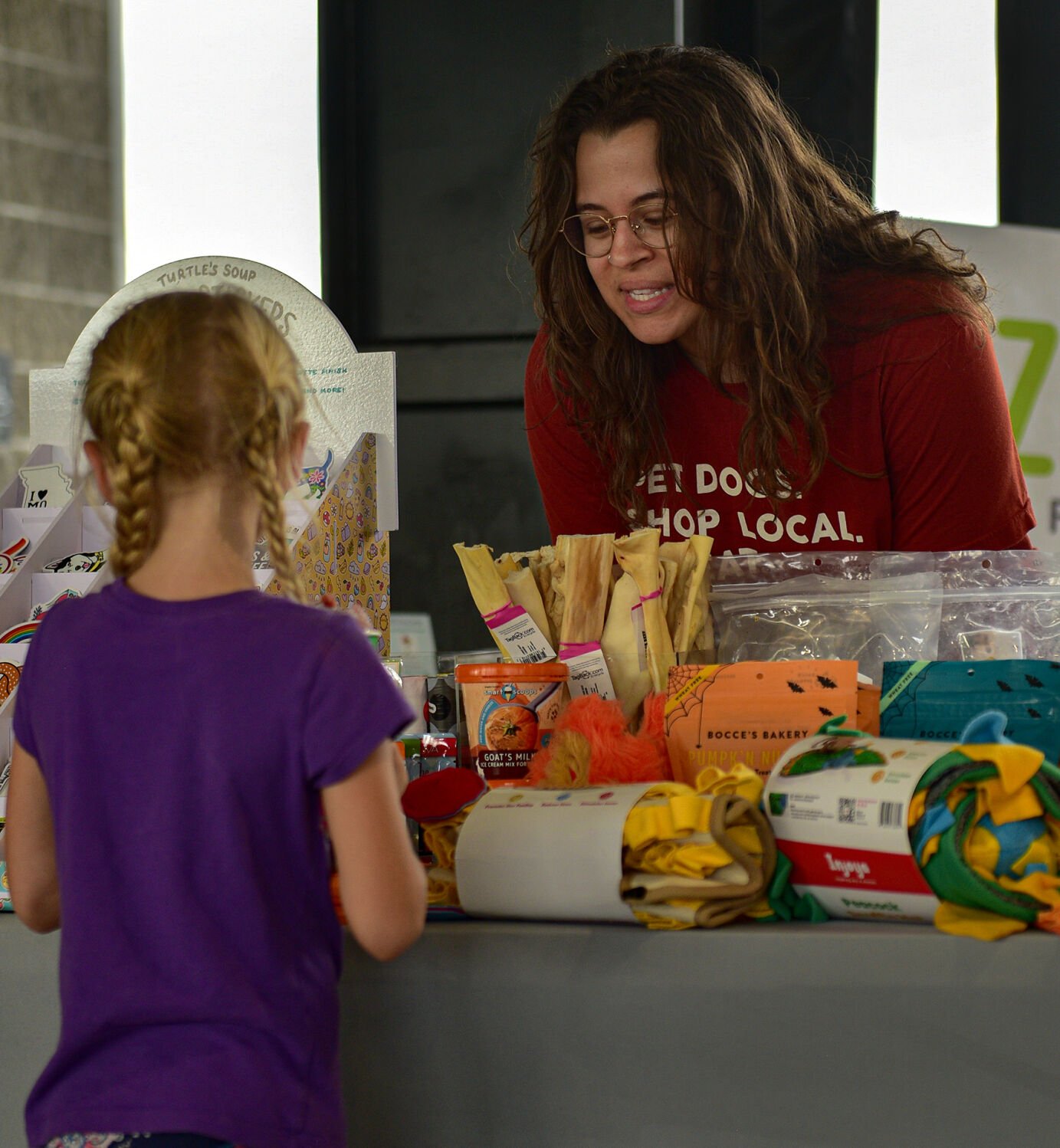 Left, Ellie Quick 6, talks with employee Kayleigh Kruckman, at the Lizzi & Rocco’s Holistic pet store booth