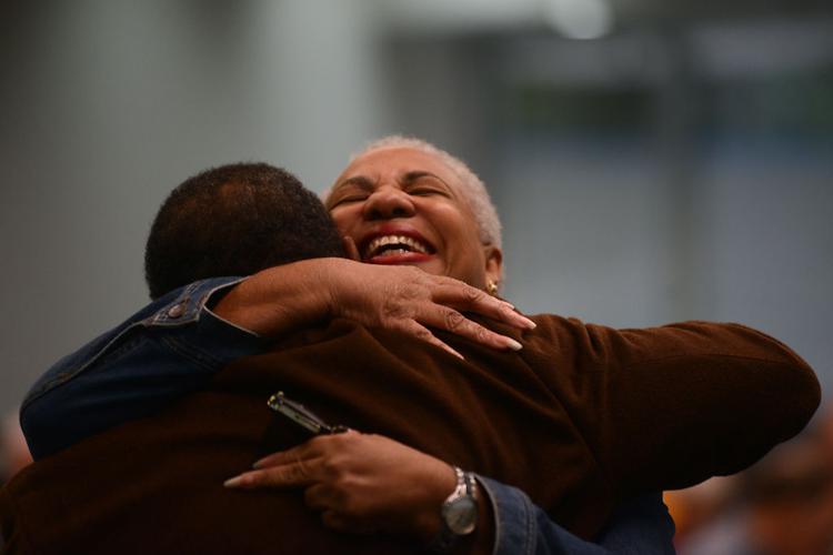Marie Glaze hugs her friend Ronald Williams at the segregation lecture series